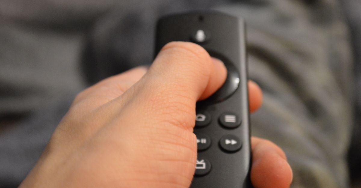 Haand med fjernkontroll klar til aa velge iptv-boks