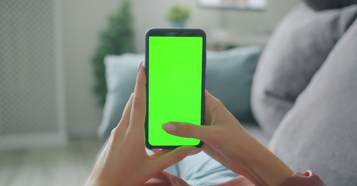 Mobilen i hånden for å sjekke vilkårene til leverandøren