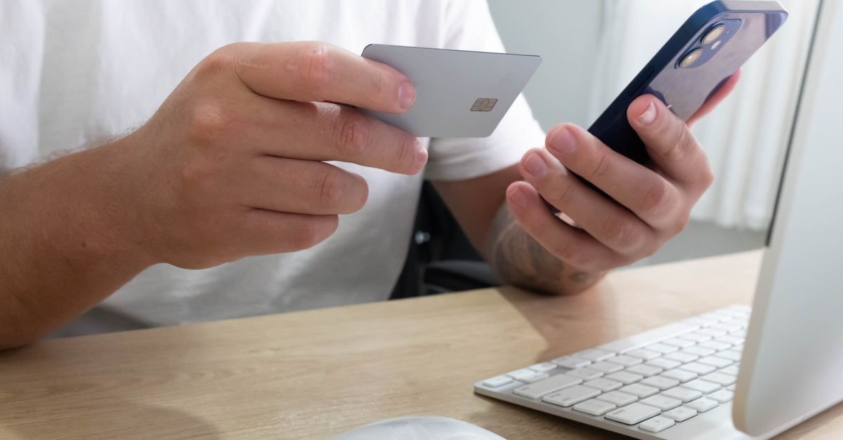 Telefon og bankkort i hendene, betalingsalternativene samlet på ett sted