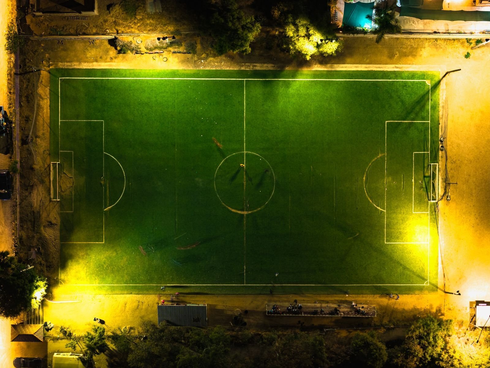 Fotballbane sett ovenfra med flombelysning en natt uten lag eller logoer