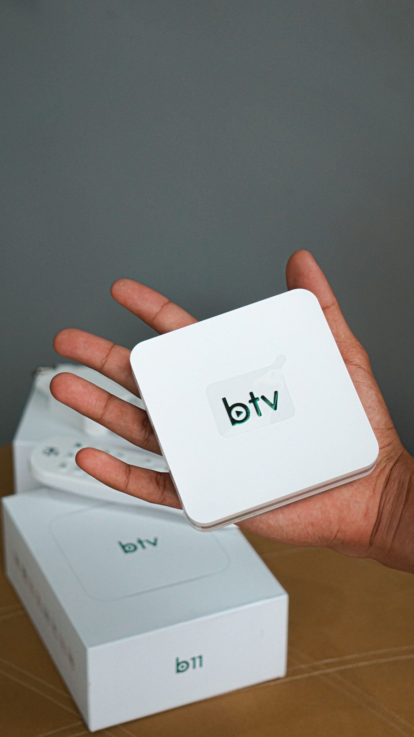 Hånd som holder en liten iptv-boks, en digital strømmeenhet for tv
