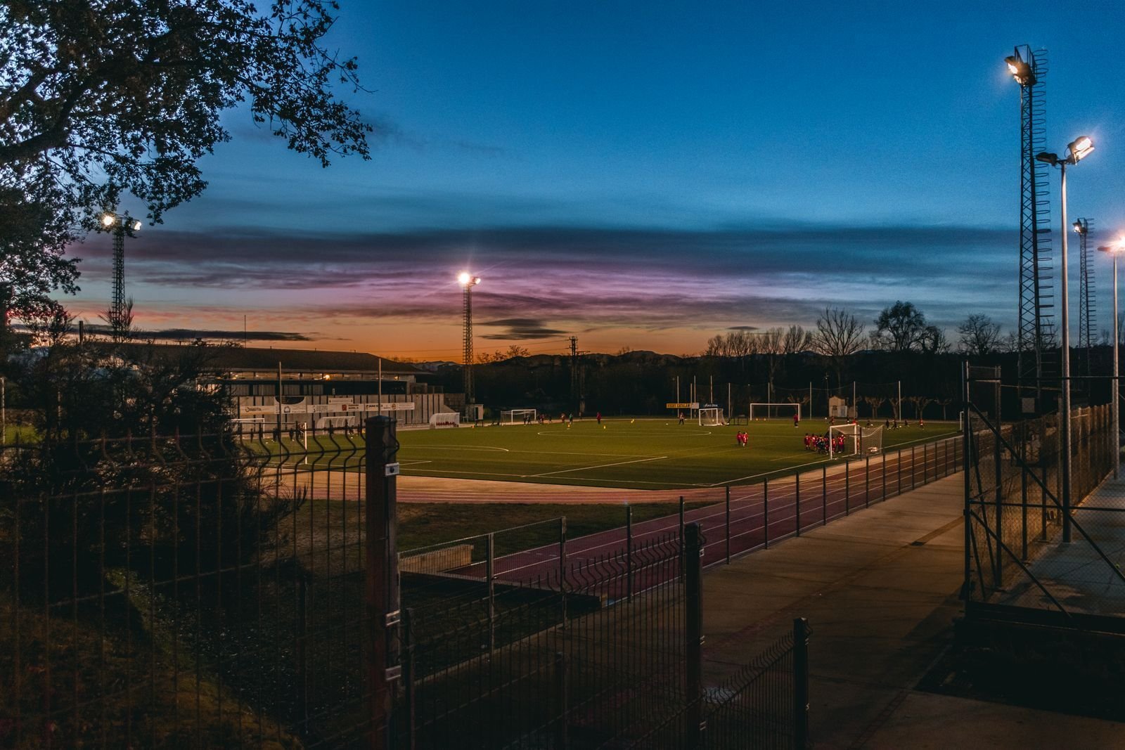 Lokal fotballbane med flombelysning i skumringen, en kveld med fotball