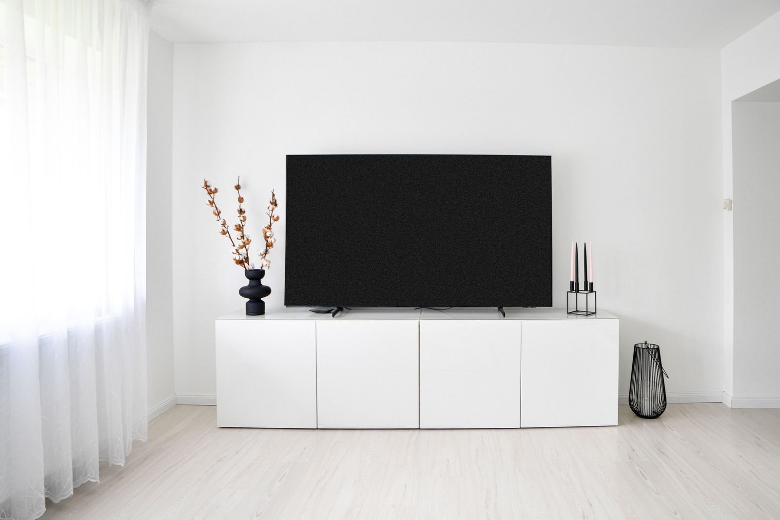 Minimalistisk skandinavisk stue med hvit innredning og tv, klar for nordisk iptv