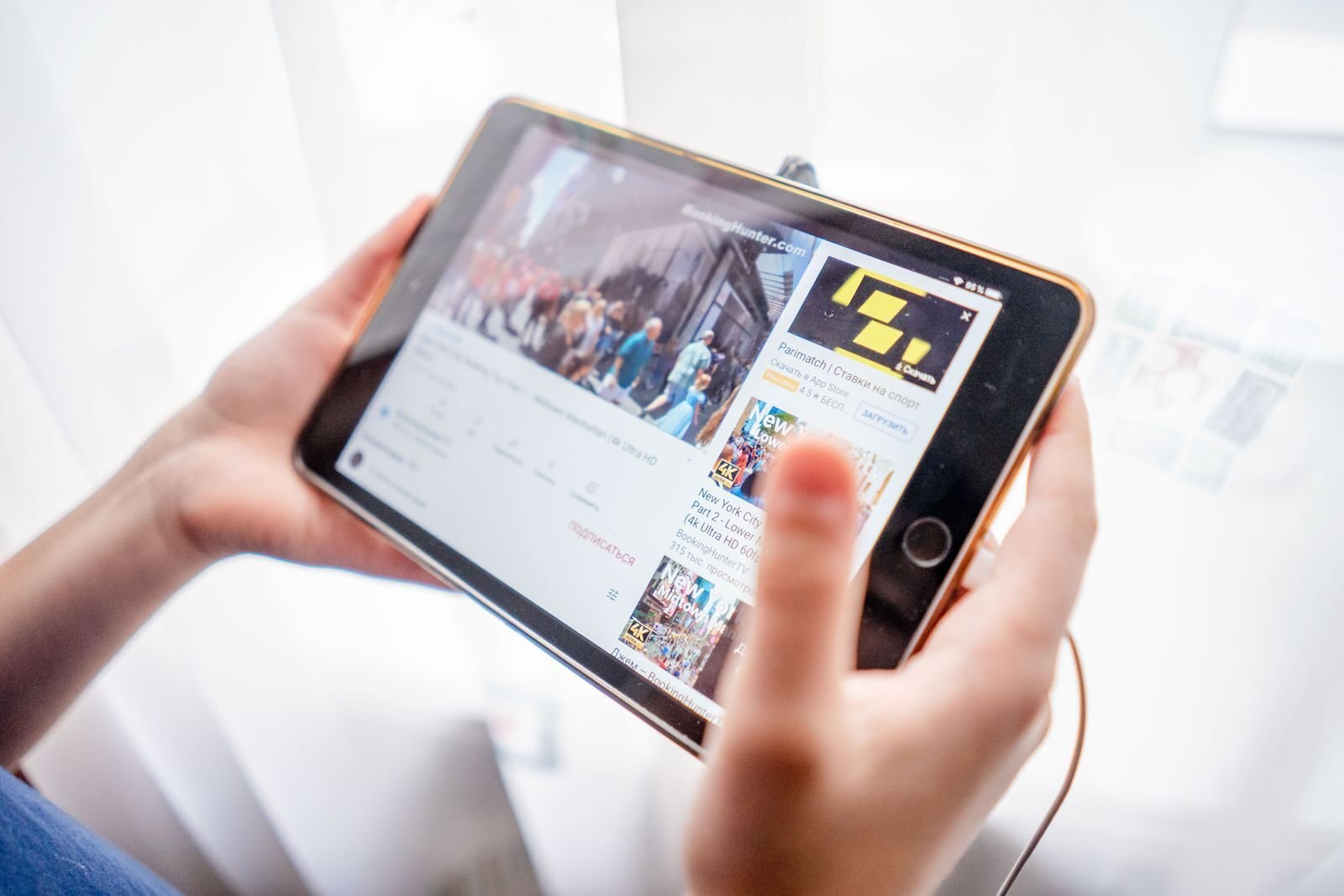 Person som holder et nettbrett og strømmer innhold via iptv