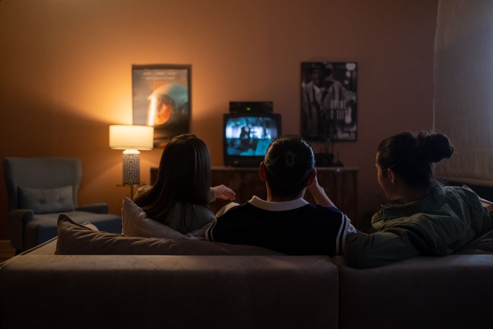 Venner som ser fotball på tv hjemme i sofaen via iptv