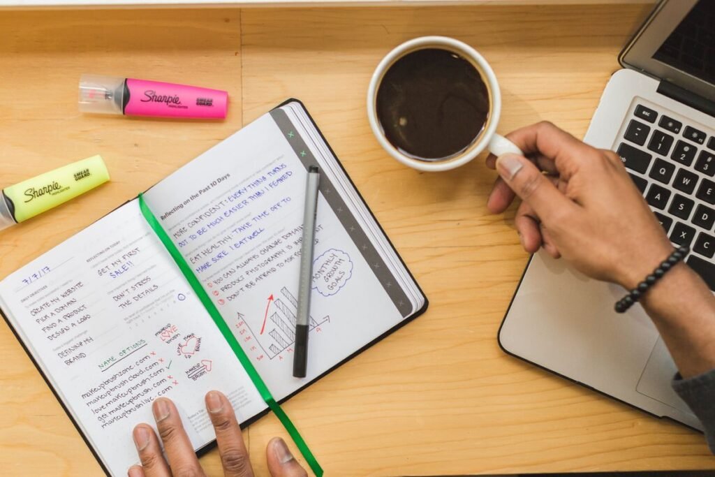 Notatbok, kaffe og laptop klare for leverandørsjekken